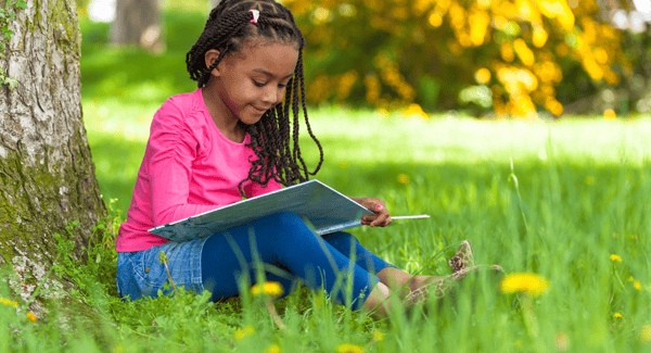 Young girl reading outside