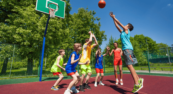 Young children playing basketball outside