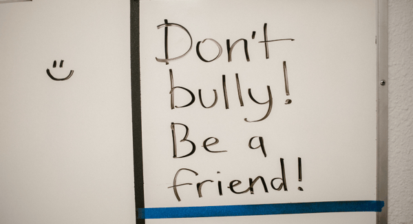 whiteboard that says 'don't bully! be a friend!'